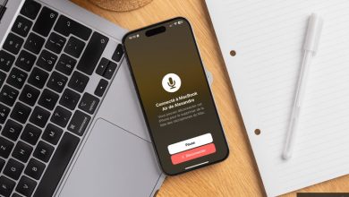 هاتف آيفون متصل بجهاز ماك بوك عبر ميزة جديدة لاستخدام ميكروفون الآيفون كمصدر صوتي على الماك، مع عرض إشعار يؤكد الاتصال ووجود خيار لإيقاف أو قطع الاتصال.